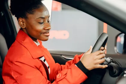 Mulher sentada ao volante de um carro avaliando o veículo antes da compra em uma concessionária na Irlanda.