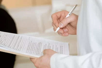 Profissional de saúde preenchendo documentação médica para avaliação de benefício social.