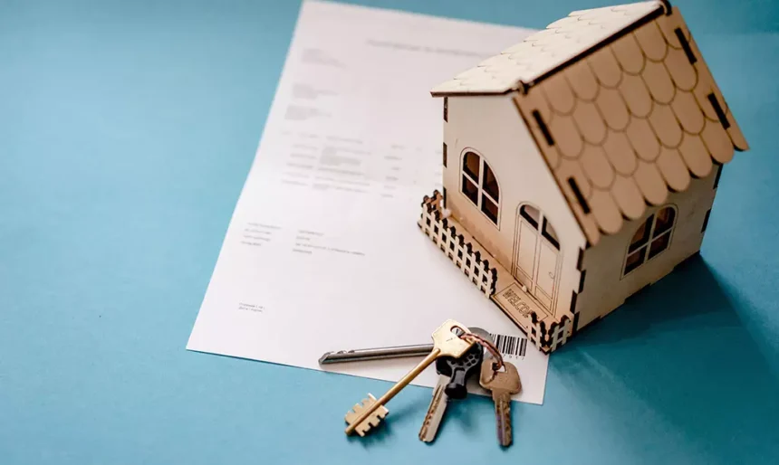 Casa em miniatura, contrato de arrendamento e chaves representando o HAP na Irlanda