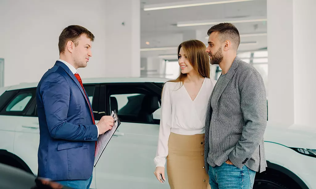 Casal analisando opções de financiamento de carro em uma concessionária na Irlanda.